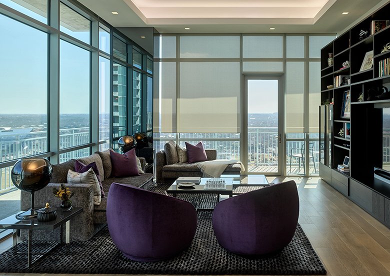 a living room with purple chairs and a table